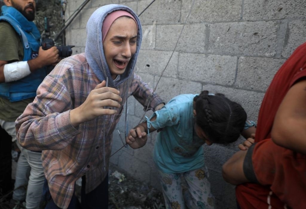 11月6日，人們從加沙地帶中部地區(qū)一處被炸難民營逃離。新華社發(fā)（亞西爾·庫迪攝）