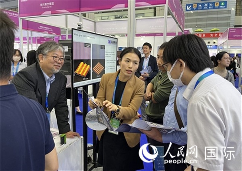 工作人員向參觀者介紹超級噴墨技術(shù)。（人民網(wǎng)記者 陳思攝）