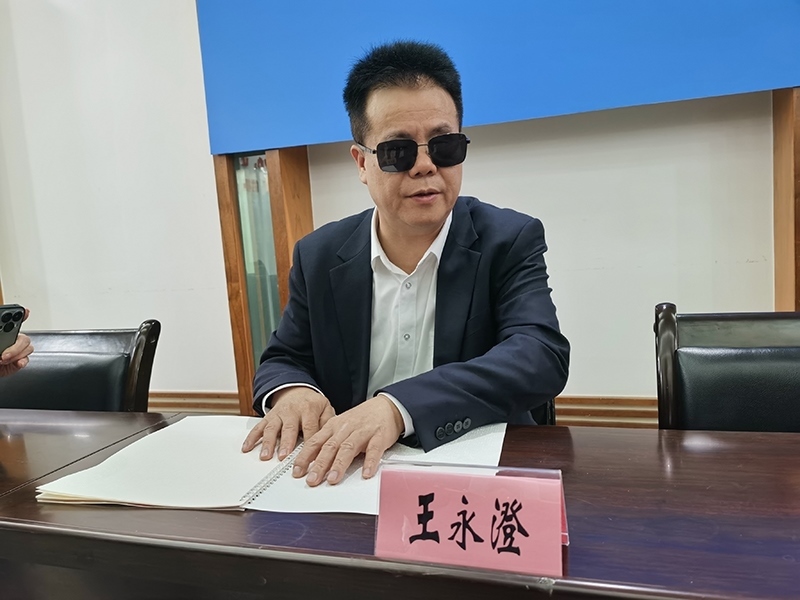 全國人大代表王永澄正在閱讀盲文版代表建議答復(fù)。本報(bào)記者 張 璁?dāng)z