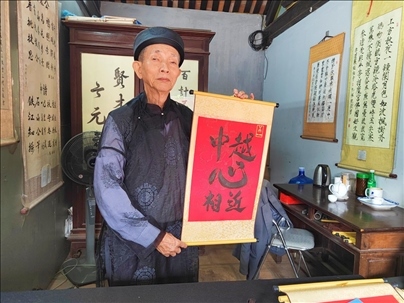 越南首都河內(nèi)文廟內(nèi)，阮明珠展示“中越心相近”書法作品。