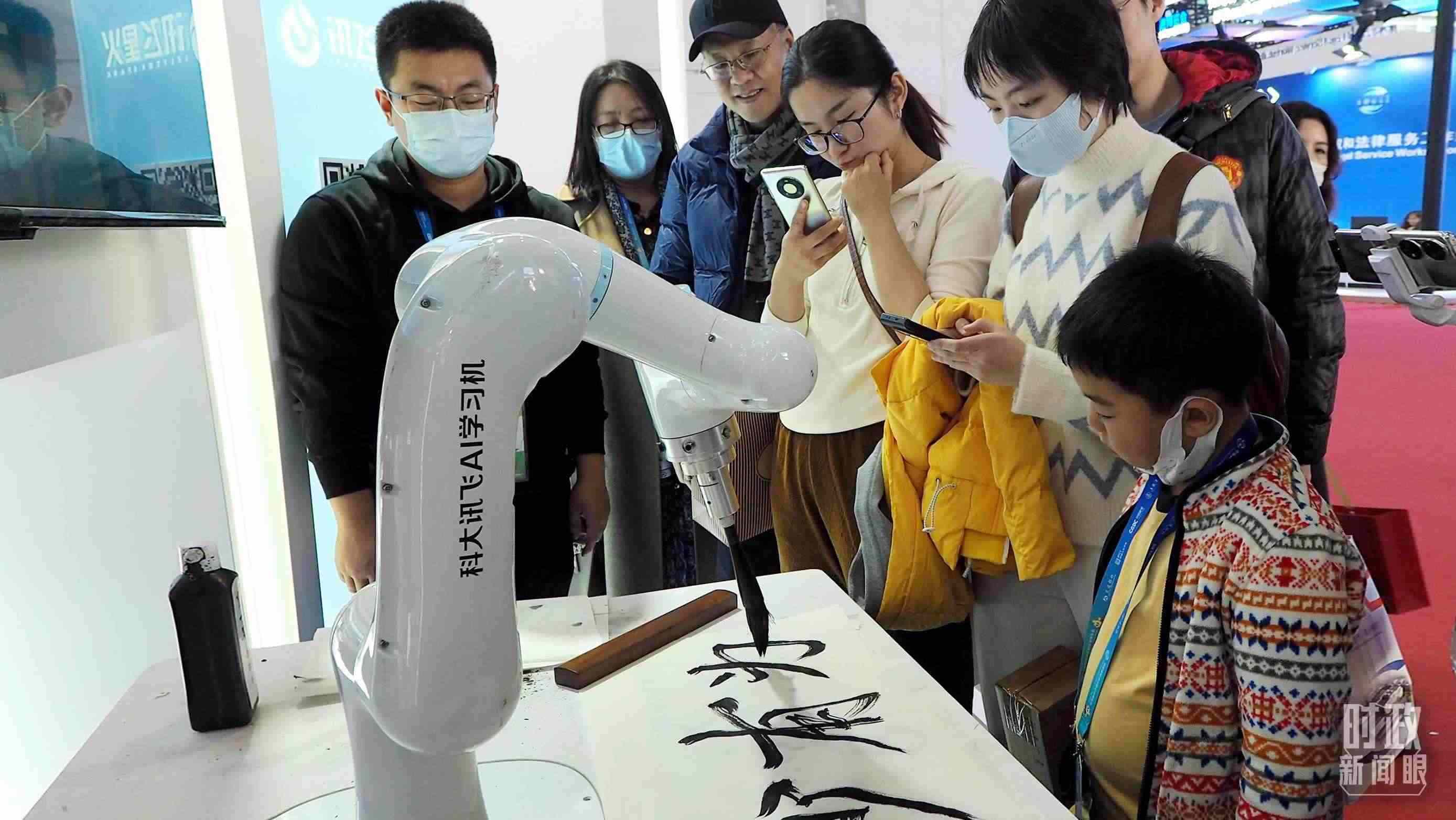 △觀眾在首屆鏈博會(huì)上體驗(yàn)AI書法機(jī)器人。