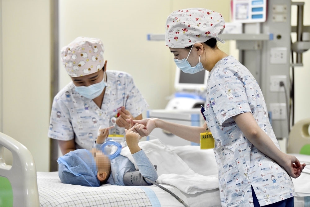 在山東省棗莊市婦幼保健院兒童ICU病房，醫(yī)護(hù)人員為完成靶向治療藥物諾西那生鈉的4歲脊髓性肌萎縮癥患兒加油鼓勁（2022年1月1日攝）。諾西那生鈉注射液是我國(guó)首個(gè)獲批治療脊髓性肌萎縮癥的進(jìn)口藥物，2019年進(jìn)入中國(guó)市場(chǎng)時(shí)，每針價(jià)格近70萬(wàn)元。在2021年國(guó)家醫(yī)保目錄藥品談判中，以3.3萬(wàn)元每針的價(jià)格進(jìn)入新版醫(yī)保藥品目錄。新華社記者 郭緒雷 攝