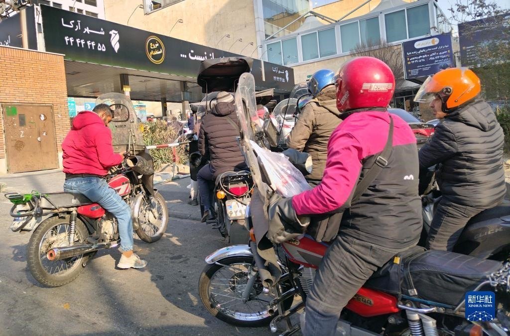 12月18日，摩托車在伊朗首都德黑蘭的一家加油站外等待加油。新華社記者 沙達(dá)提 攝