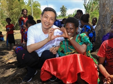 2023年12月18日，中國駐瓦努阿圖大使李名剛和前來觀看瓦努阿圖公路項目二期馬勒庫拉段移交儀式的當(dāng)?shù)鼐用窈嫌?。人民網(wǎng) 賀吉攝