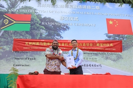 2023年12月18日，瓦努阿圖基礎(chǔ)設(shè)施和公共事業(yè)部長瑞克·查馬克·馬赫（左）和中土南太公司總經(jīng)理梁慶（右）在馬勒庫拉諾索普機(jī)場升級改造二期項目的簽約儀式上握手。人民網(wǎng) 賀吉攝