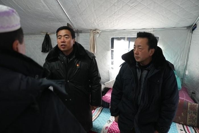 2023年12月22日，積石山縣大河家鎮(zhèn)大河村黨支部書記馬成忠（右二）在帳篷里和受災群眾交流。新華社記者 陳斌 攝