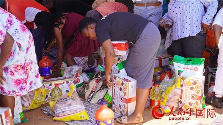 當(dāng)?shù)厣鐓^(qū)家庭領(lǐng)取物資。人民網(wǎng) 張茜攝