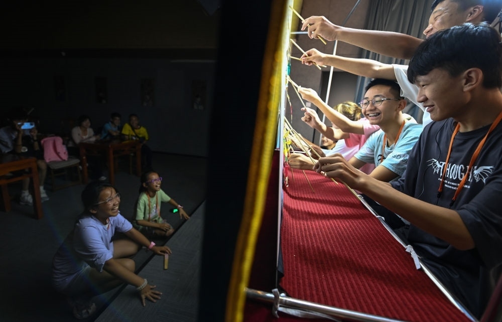 2023年8月8日，進(jìn)行暑期研學(xué)的學(xué)生在位于陜西省西安市的中國秦腔藝術(shù)博物館體驗(yàn)皮影戲演出。新華社記者 鄒競一 攝