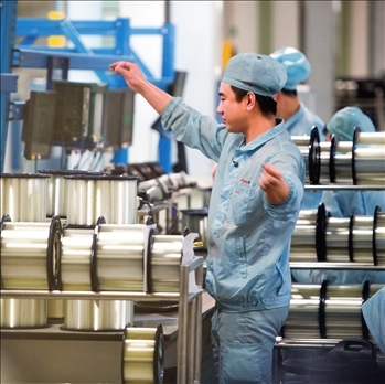 在位于武漢的長飛光纖光纜股份有限公司光纖生產車間內，工作人員對光纖進行檢測（資料圖片）。肖藝九攝/本刊