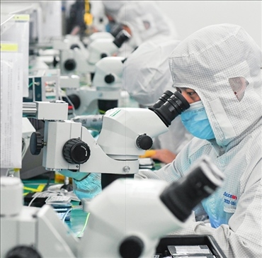 在位于武漢中國光谷的光電器件研發(fā)制造商——武漢光迅科技股份有限公司生產車間內，技術人員在光模塊生產線作業(yè)（2023年4月11日攝）。程敏攝/本刊