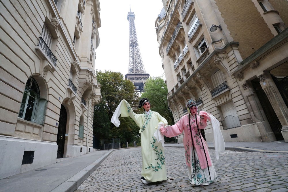 2023年9月13日，江蘇省演藝集團(tuán)昆劇院院長(zhǎng)施夏明（左）和江蘇省演藝集團(tuán)昆劇院國(guó)家一級(jí)演員孔愛(ài)萍在法國(guó)巴黎埃菲爾鐵塔附近參加昆曲快閃。新華社記者 高靜 攝