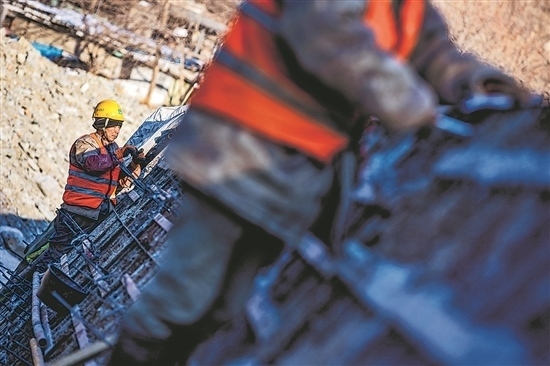 1月3日，房山區(qū)，工人正在雙泉河修筑堤壩。