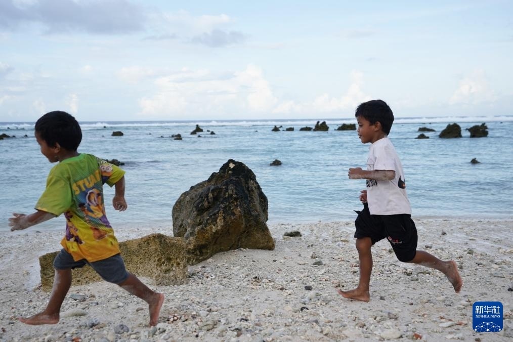 1月20日，兒童在瑙魯海邊嬉戲。新華社記者 王申 攝