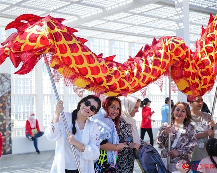 游客體驗舞龍。 人民網(wǎng) 塔里克·易卜拉欣攝