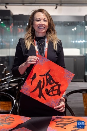 1月28日，在上海豫園舉行的民俗活動(dòng)上，美國(guó)馬斯卡廷初中校長(zhǎng)珍妮弗·李·弗里德利展示自己寫下的“?！弊?。 新華社記者 王翔 攝