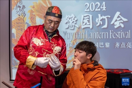 1月28日，在上海豫園舉行的民俗活動(dòng)上，美國(guó)馬斯卡廷中學(xué)學(xué)生在非遺傳承人的指導(dǎo)下吹糖偶。 新華社記者 王翔 攝