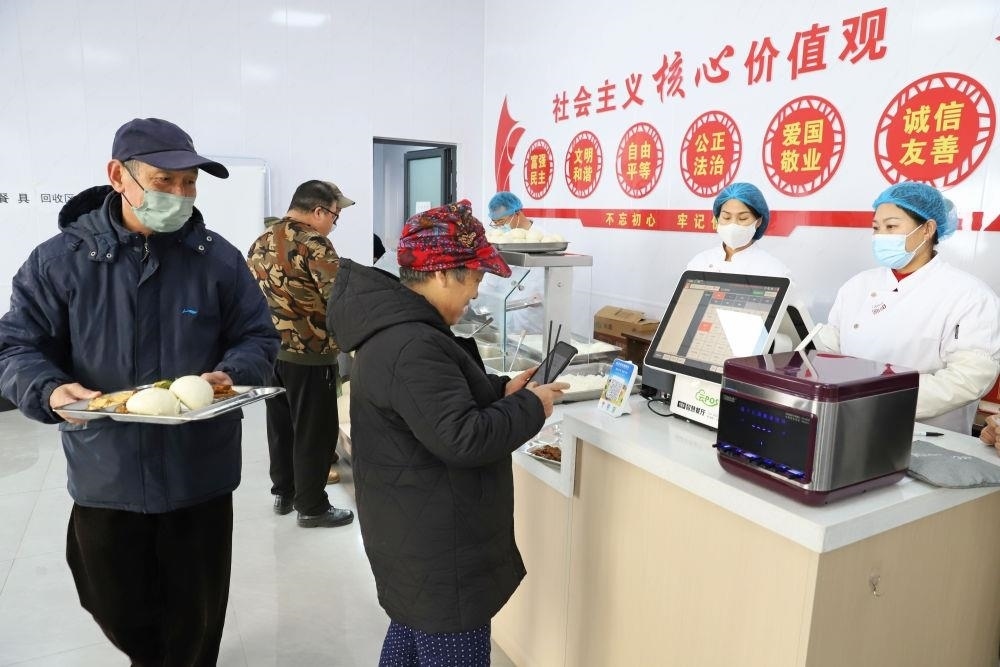 △2024年2月1日，市民在河北涿州市雙塔街道永濟秀園小區(qū)便民食堂內(nèi)購買午餐。