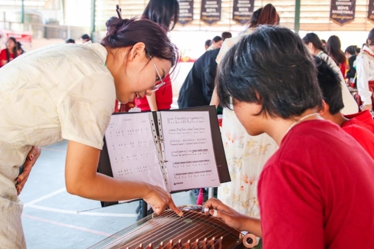 志愿者教師指導(dǎo)學(xué)生彈奏古箏?；顒?dòng)主辦方供圖