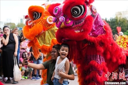 圖為舞獅表演吸引民眾合影。張興龍攝