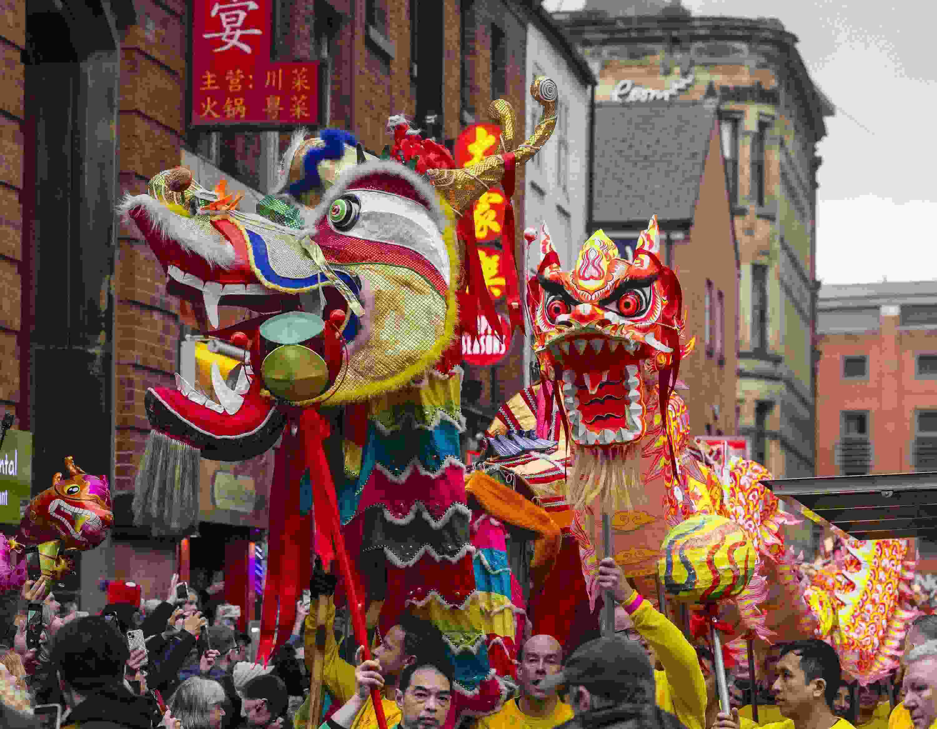 △ 當?shù)貢r間2024年2月11日，英國曼徹斯特，表演者進入中國城，參加中國農(nóng)歷龍年春節(jié)的慶?；顒印? width=