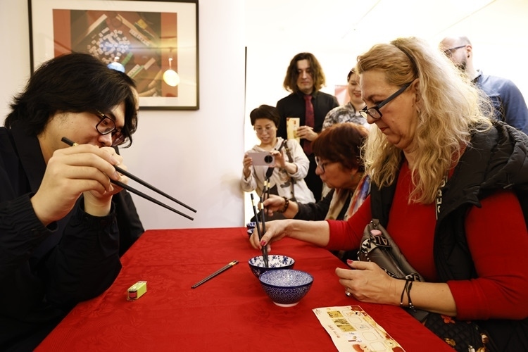 羅馬尼亞觀眾體驗(yàn)用筷子夾花生。中國(guó)文化中心供圖