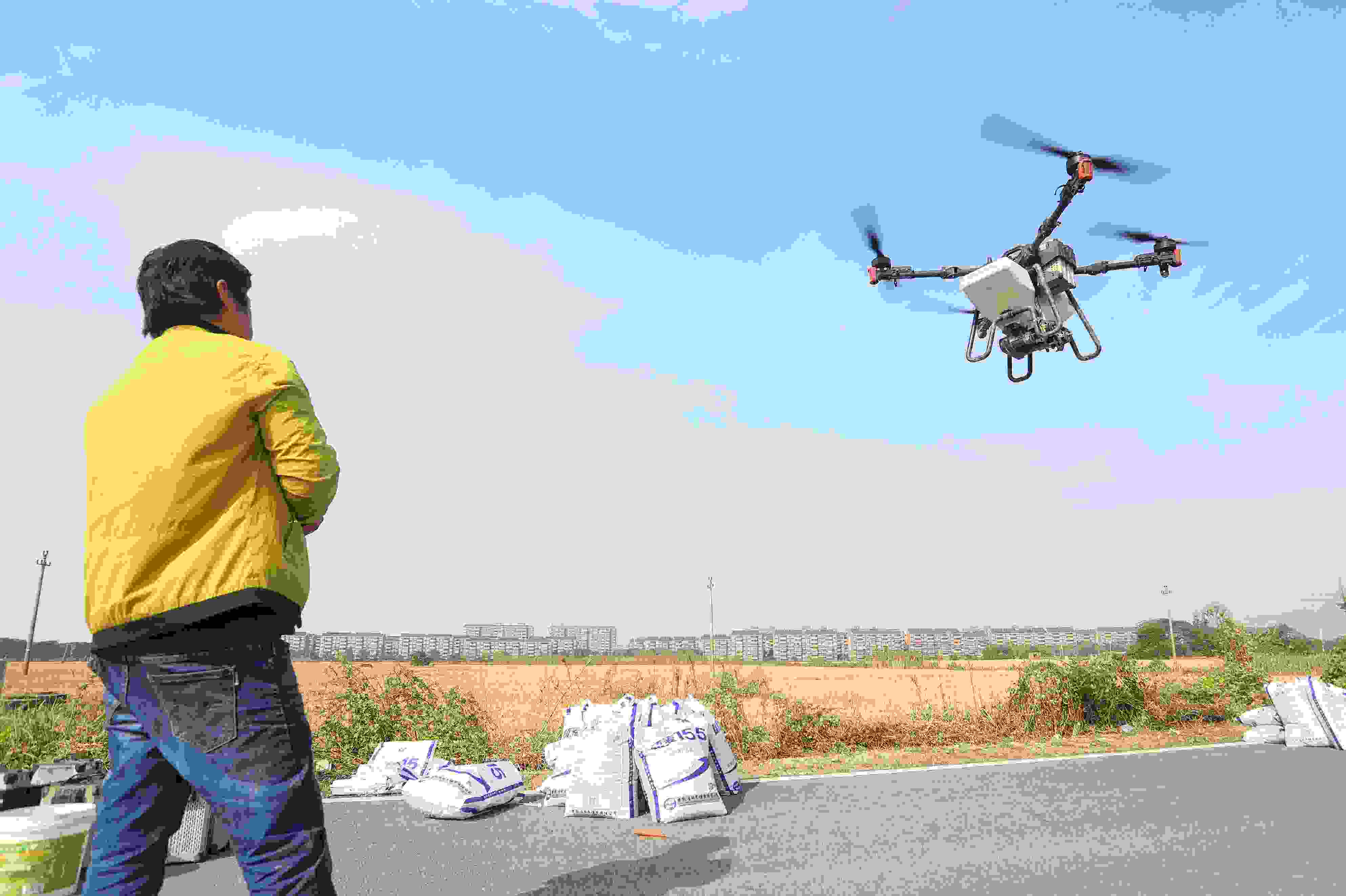 2023年11月15日，浙江嘉興，南湖區(qū)七星街道一處農(nóng)田里，農(nóng)民操縱無人機進行冬小麥飛播。