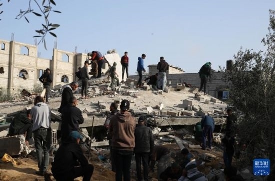  3月3日，在加沙地帶南部城市拉法，人們查看被以軍空襲破壞的建筑。新華社發(fā)（哈立德·奧馬爾攝）