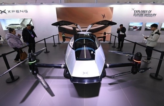 2023年12月1日，在鏈博會智能汽車鏈展區(qū)小鵬汽車展臺，參觀者觀看一臺智能飛行器。新華社記者蔡湘鑫攝