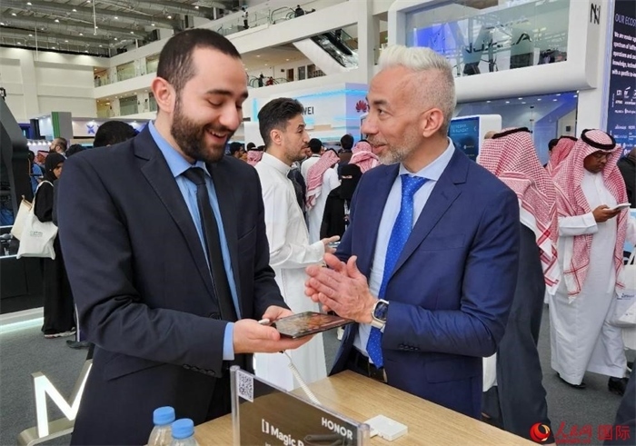 兩名觀眾在榮耀手機(jī)展臺前交流。人民網(wǎng)記者 管克江攝