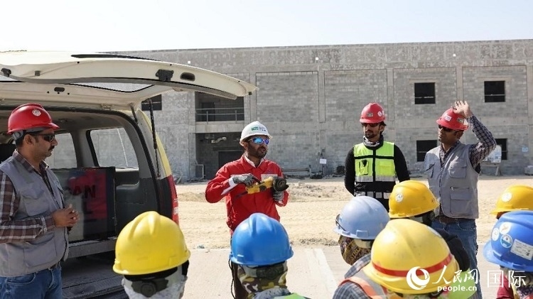 穆薩瓦爾(圖中紅衣人）現(xiàn)場(chǎng)演示工具操作規(guī)范。人民網(wǎng)記者 管克江攝