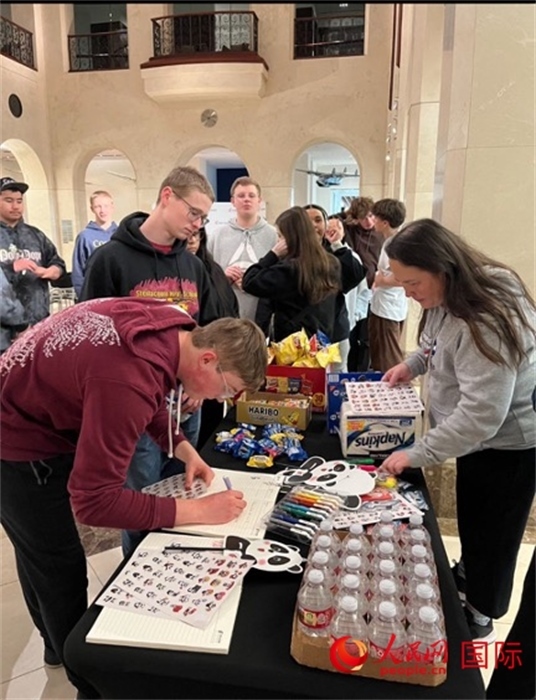 學(xué)生們出發(fā)前紛紛在留言簿留言。人民網(wǎng)記者 鄧圩攝