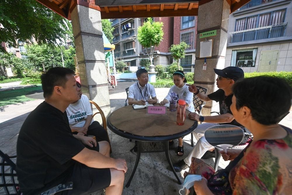 △2023年7月21日，在位于浙江杭州臨安區(qū)錦南街道水岸陽光小區(qū)的陽光議事廳，街道干部在聽取居民們反映的問題及意見。