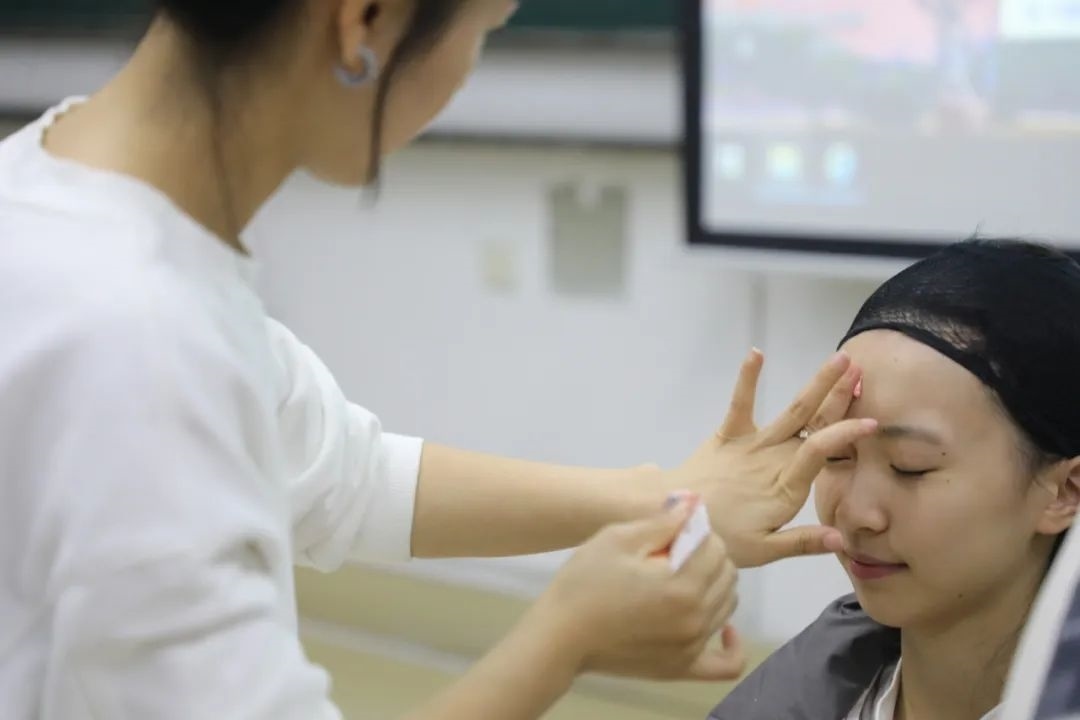 課堂上，一名學(xué)生在體驗(yàn)上戲妝。學(xué)校供圖