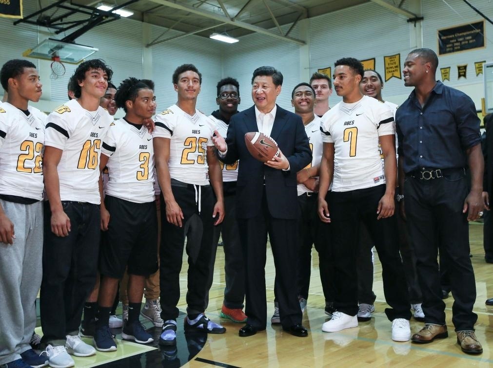 2015年9月23日，國家主席習(xí)近平參觀美國塔科馬市林肯中學(xué)。這是習(xí)近平在學(xué)校體育館，同上橄欖球訓(xùn)練課的學(xué)生們親切交談。新華社記者 蘭紅光 攝