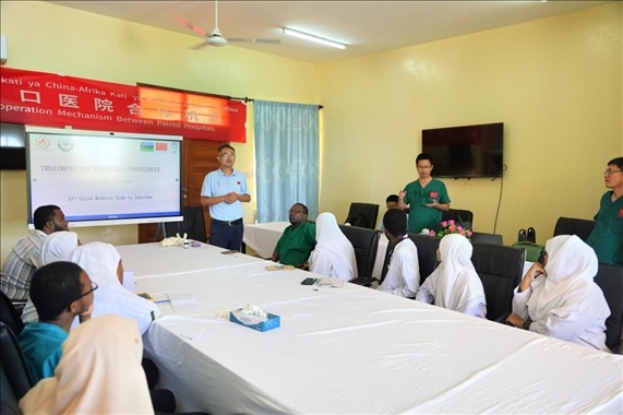 隊長蔣國慶和韋長群醫(yī)生一起解答問題。中國援桑醫(yī)療隊供圖