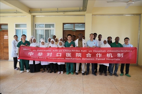 醫(yī)療隊隊員和當(dāng)?shù)蒯t(yī)生們合影。中國援桑醫(yī)療隊供圖