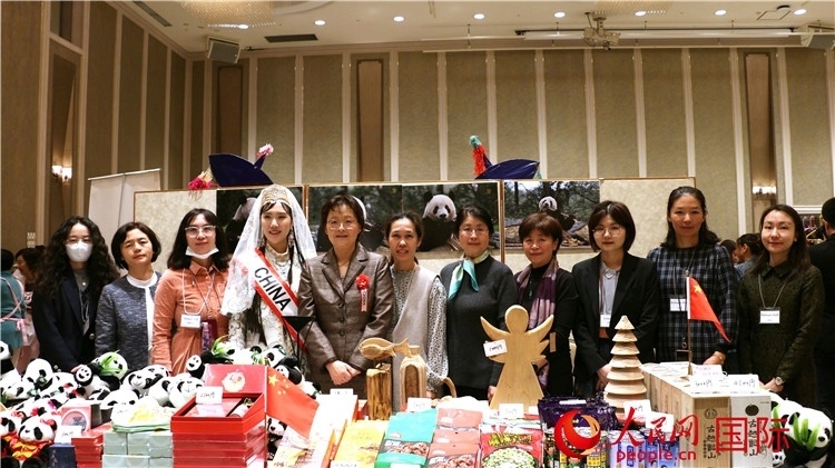 中國駐日本大使吳江浩夫人丁玥（左五）與使館人員在展位前合影留念。人民網(wǎng) 許可攝