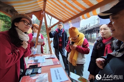 1月6日，“2024成都蒲江柑甜采摘節(jié)”上，記者見到了小萌（左一）和許多年輕人忙著做訪客接待、現(xiàn)場布置、票務(wù)核對、采摘服務(wù)等工作。人民網(wǎng)記者朱虹攝