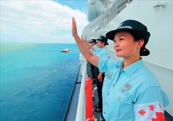 中國(guó)海軍“和平方舟”號(hào)醫(yī)院船結(jié)束訪問(wèn)湯加時(shí)，任務(wù)官兵中的文職人員向歡送人群揮手告別（2023年8月4日攝）。徐巍攝/本刊