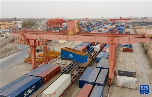 4月21日，二連浩特鐵路口岸龍門吊吊裝中歐班列集裝箱（無(wú)人機(jī)照片）。 新華社發(fā)（張海峰攝）