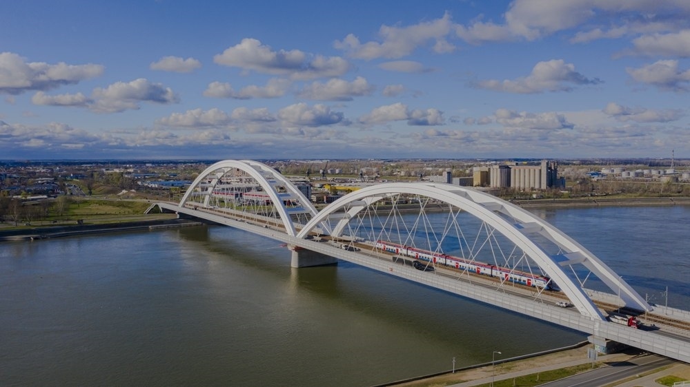 2024年3月12日，一列火車運(yùn)行在匈塞鐵路塞爾維亞境內(nèi)貝諾段諾維薩德多瑙河大橋上（無人機(jī)照片）。新華社發(fā)（任衛(wèi)云攝）