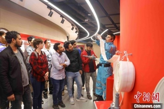 5月9日，工作人員指導(dǎo)留學(xué)生正確使用消防水帶。張鷹 攝