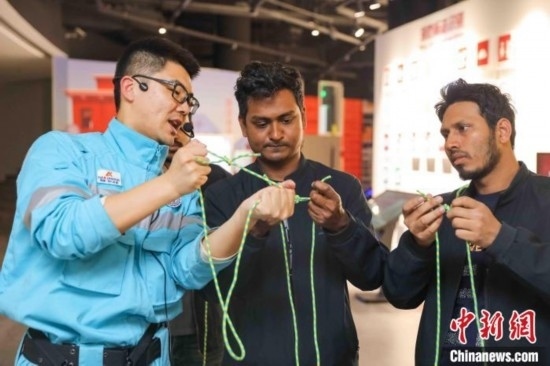 5月9日，工作人員指導(dǎo)留學(xué)生學(xué)習(xí)打繩結(jié)。張鷹 攝