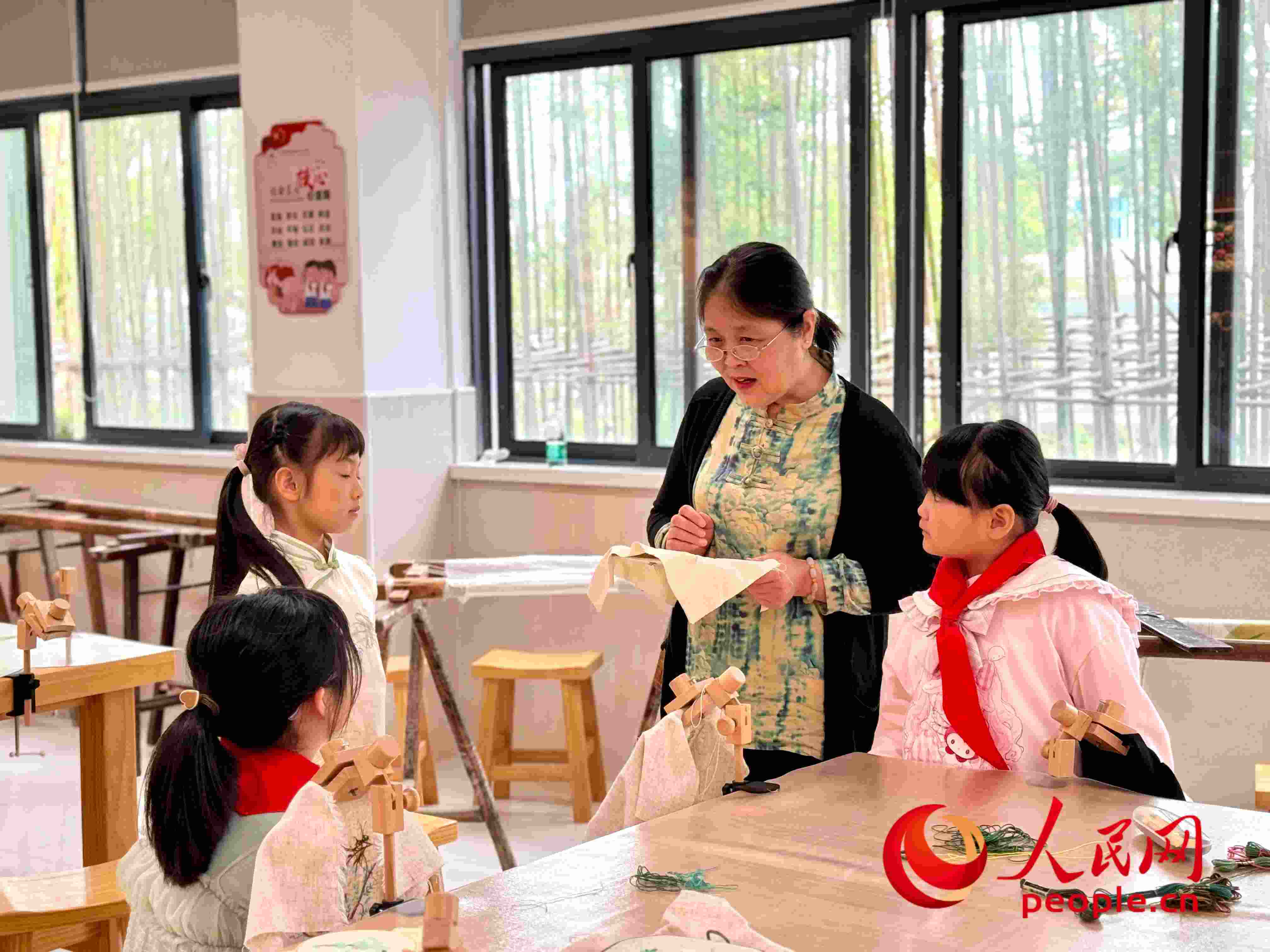顧建珍（左三）在教孩子們刺繡知識(shí)。人民網(wǎng) 周靜圓攝
