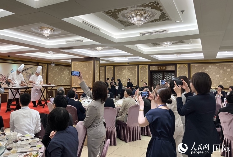 國(guó)家級(jí)非物質(zhì)文化遺產(chǎn)、全聚德片鴨工藝吸引代表團(tuán)成員拍照留念。