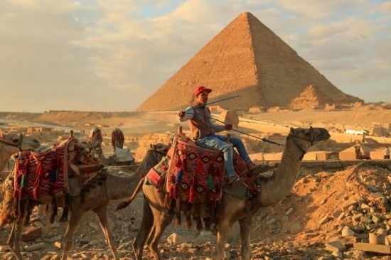 1月24日，商販騎駱駝離開埃及吉薩金字塔景區(qū)。新華社記者 隋先凱 攝