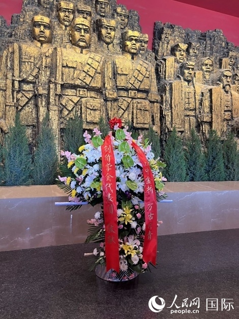 創(chuàng)價學(xué)會青年代表團(tuán)敬獻(xiàn)的花籃上，寫有“愿日中金橋萬古長青”。人民網(wǎng)記者 陳思攝