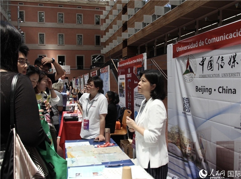 旅西華人華僑在展臺前咨詢。人民網(wǎng)記者 許海林攝