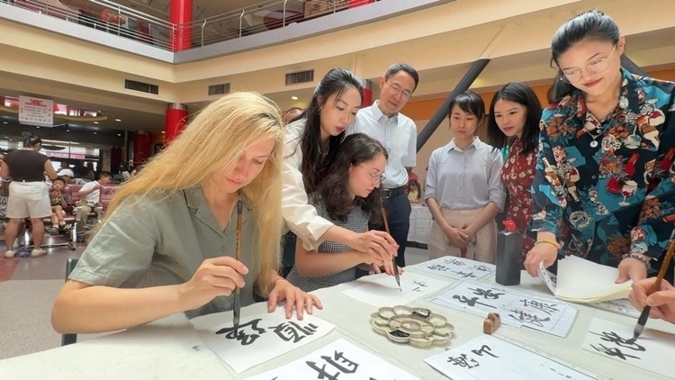 羅馬尼亞友人在活動(dòng)現(xiàn)場(chǎng)學(xué)寫漢字。中國(guó)駐羅馬尼亞大使館領(lǐng)僑處供圖