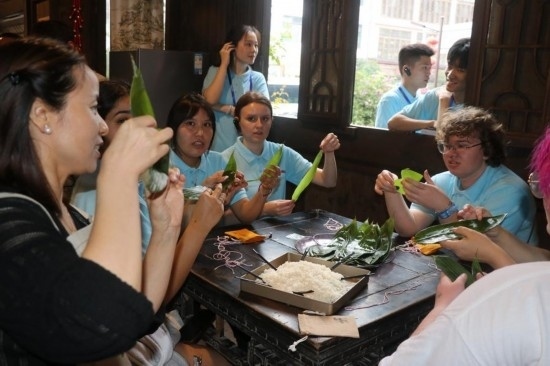 6月9日，美國(guó)青年代表在重慶永川松溉古鎮(zhèn)體驗(yàn)包粽子。新華社記者 周思宇 攝